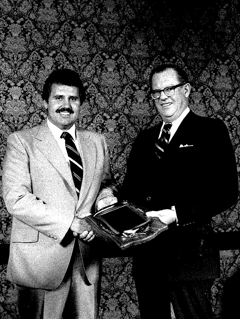 Dave Westlake receiving a business award in a handshake presentation